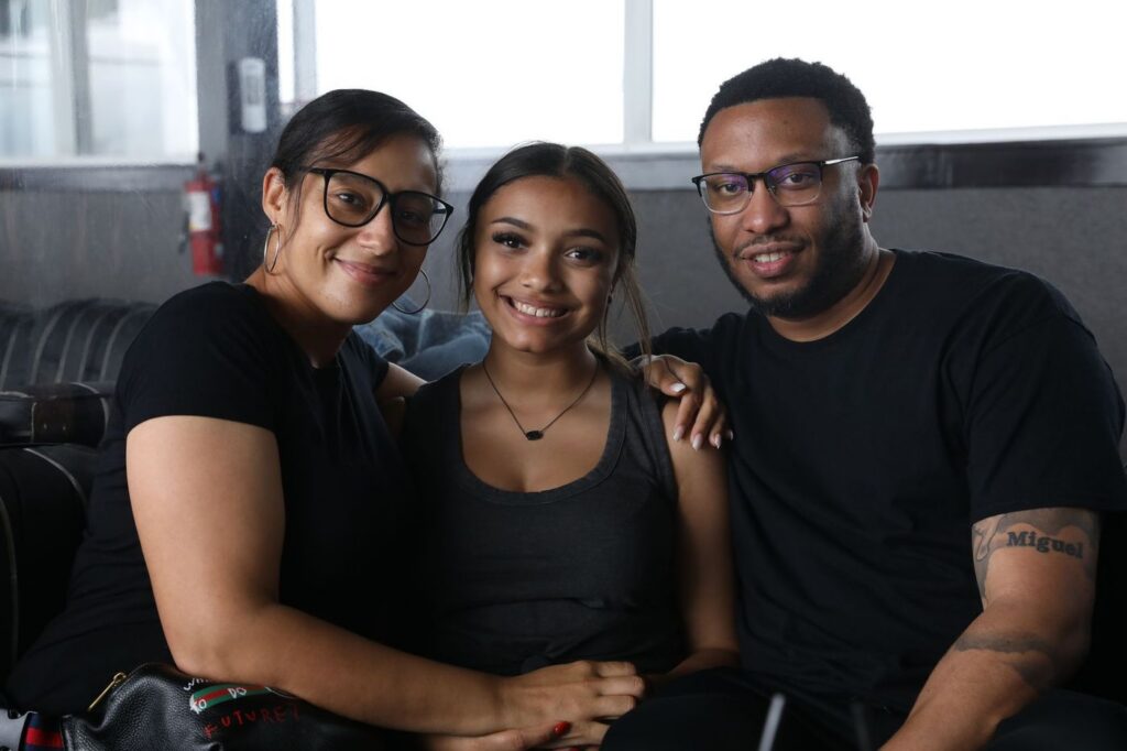 Smiling family of three hugging at home