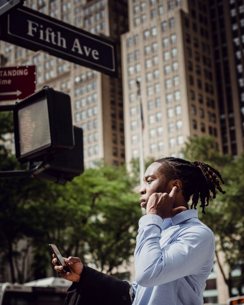 Man talking on his phone at the corner of Fifth Avenue in New York City